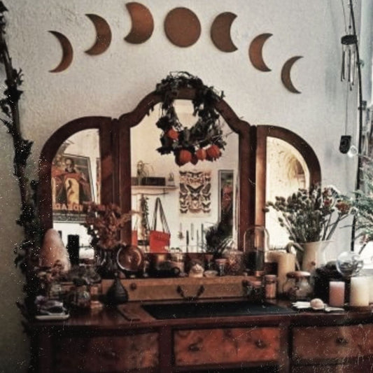 Witches altar with moons over a mirror.